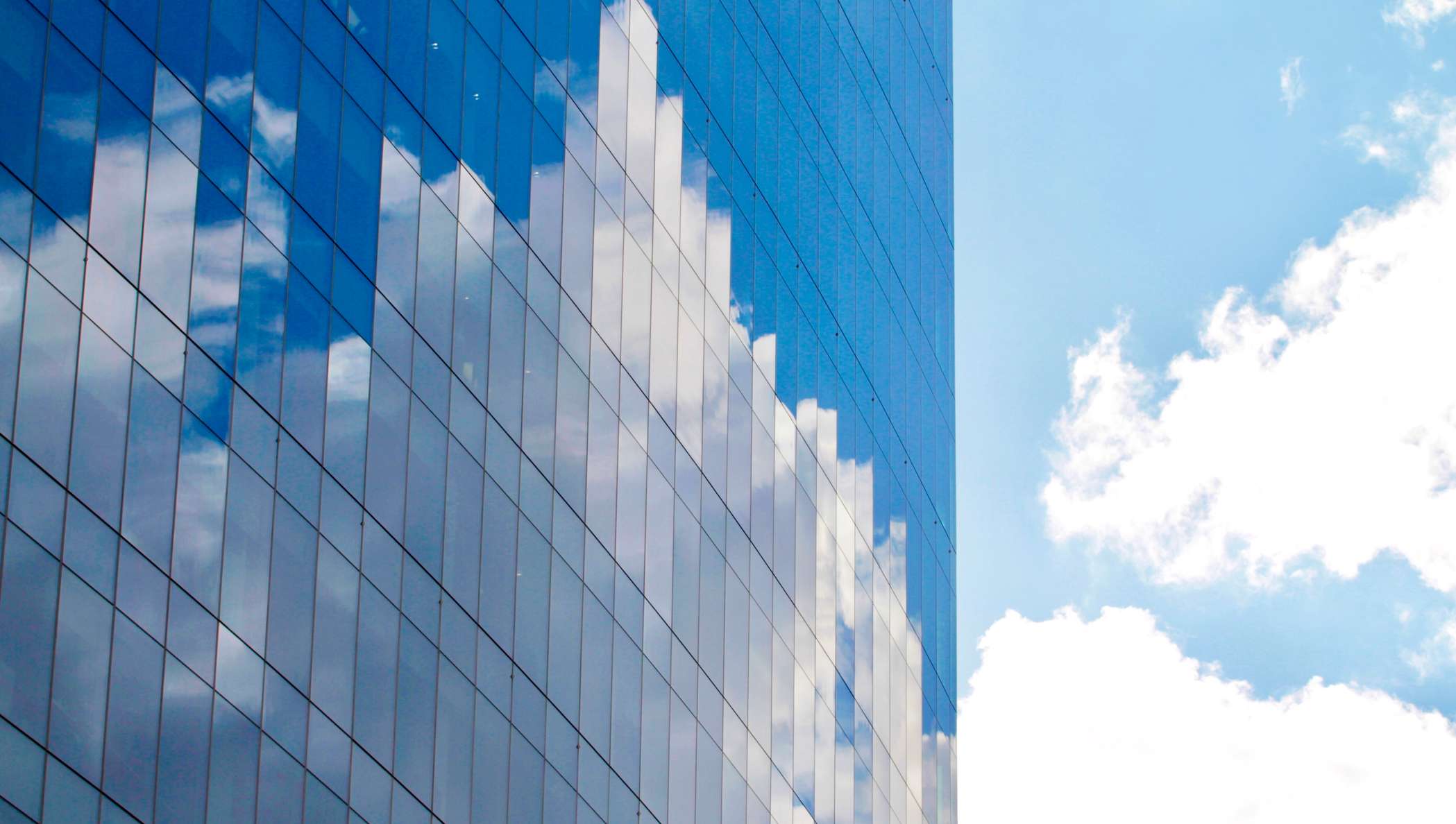 雲と青空が反射する高層ビル